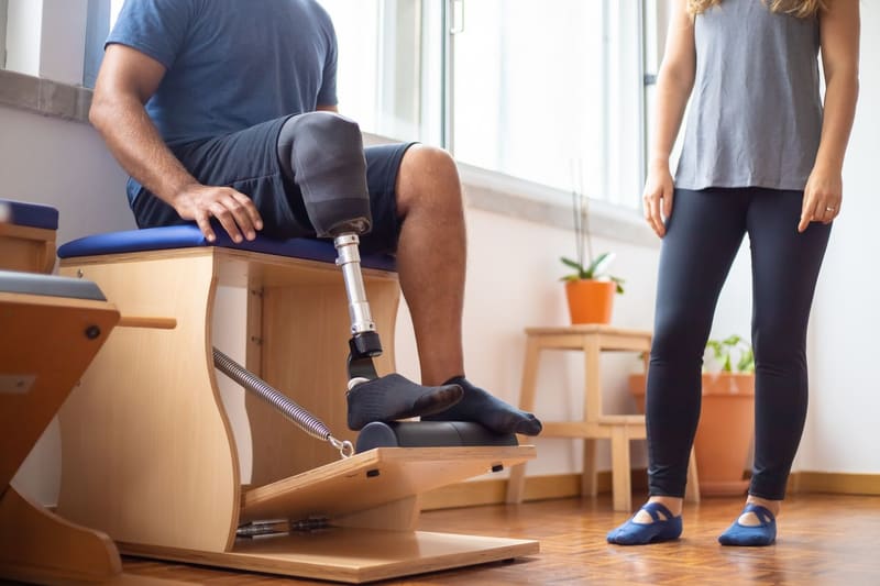 Amputee patient using a prosthetic leg during rehabilitation therapy